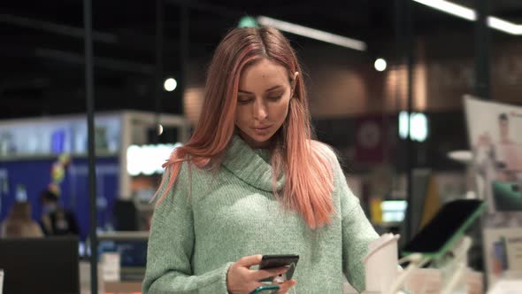 Female Customer is Taking Mobile Phone From Counter and Testing It