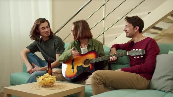 Friends are Playing Guitar and Having a Good Time Together