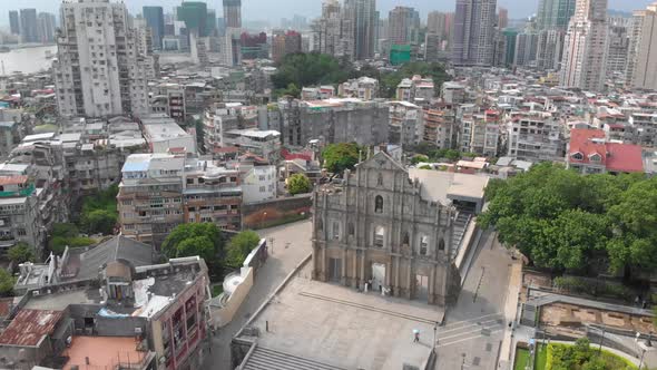 Rotating and tilting aerial view of Ruins of Saint Paul's revealing Macau cityscape