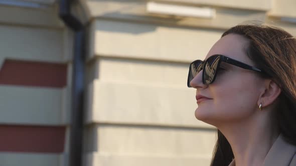 Profile of Young Successful Businesswoman in Sunglasses Walking at Sidewalk