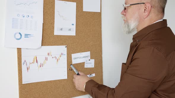man examines the charts of the stock market