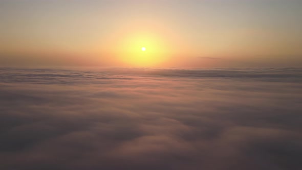 Aerial View From Airplane Window at High Altitude of Dense Puffy Cumulus Clouds Flying in Evening