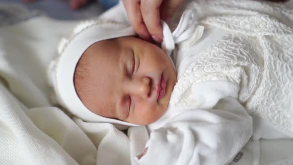 Newborn Baby Sleeps in White Clothes