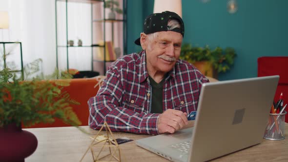Senior Grandfather Man Typing Credit Cards Information on Laptop Making Internet Online Shopping