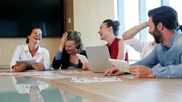 Smiling business team interacting with each other in conference room