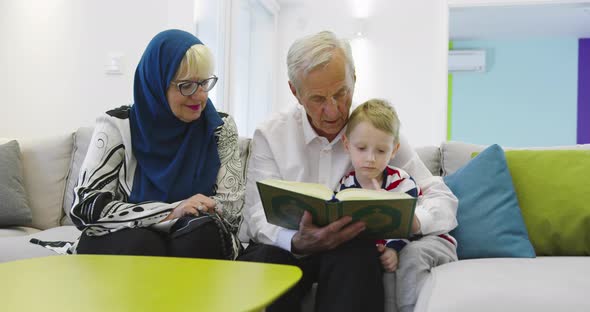 Muslim Family Generations Grandparents Reading Quran with Grandchildren at Home