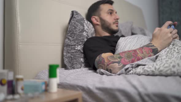 Man in Home Quarantine Playing Video Games Lying in Bed