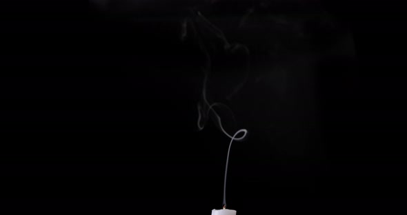 White smoke isolated on black background. White smoke slowly floating up from the white candle