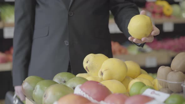 Unrecognizable Young Caucasian Man Selecting Yellow Pears in Grocery. Male Vegan Choosing Fruit From