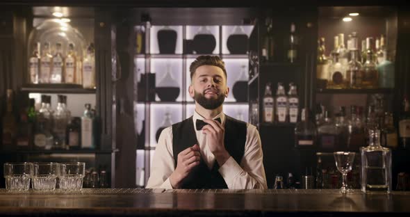 The Bartender Is Smiling and Adjusting the Bow Tie. 