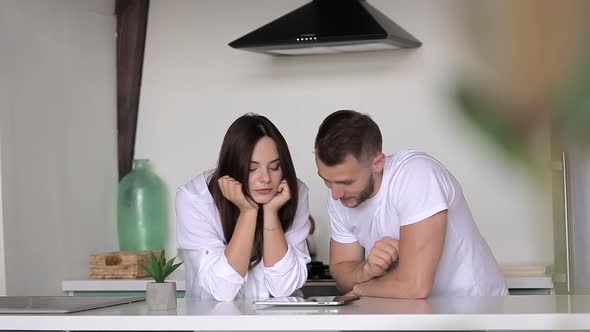A guy and a girl are browsing products in an online store on a tablet