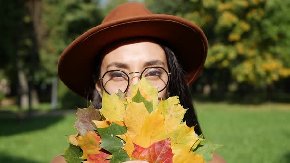 Portrait of a Beautiful Middle Eastern Smiling Woman Holding a Bouquet of Colorful Leaves in Her