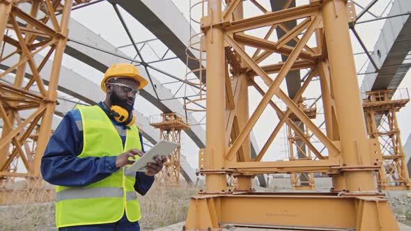 African-American Construction Supervisor Inspecting Site