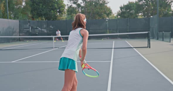 Redheaded Teen During a Tennis Match with Her Coach