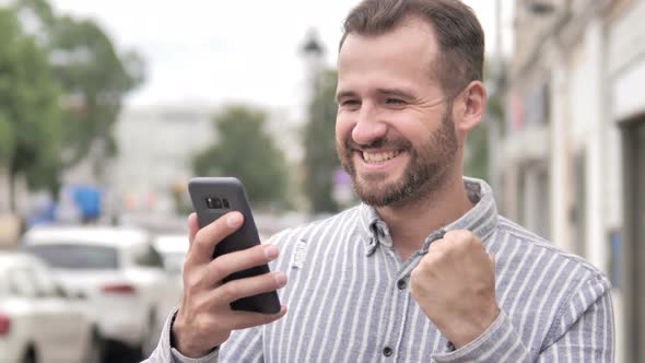 Man Excited for Success on Smartphone