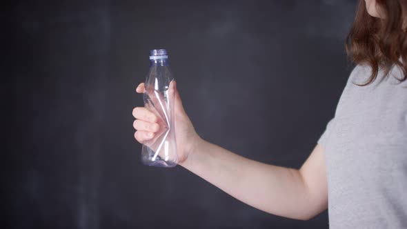 Crumpling Plastic Bottle On Dark Background