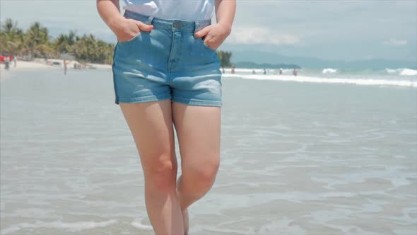 On a Tropical Beach Close-Up of Women's Legs European Beautiful Brunette, Walking Along the Beach