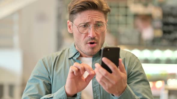 Portrait of Upset Middle Aged Man Having Loss on Smartphone