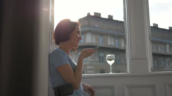 Portrait of Smiling Woman Using Smartphone Voice Recognition