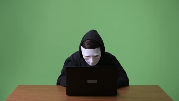 Young Teenage Boy Computer Hacker Against Green Background