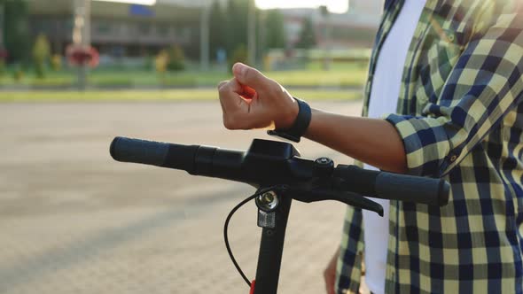 Unrecognizable Tourist Man Take Electric Kick Scooter or Bike Bicycle with Smart Watch Application