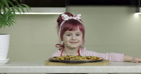 Cooking Pizza. Little Child in Apron with Freshly Baked Hot Pizza in Kitchen