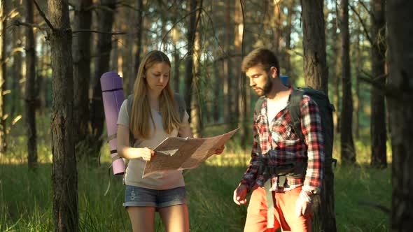 Attractive Young Campers Looking at Map for Navigation Right Way Search in Woods