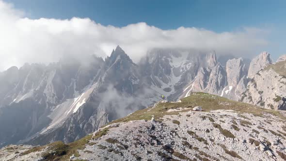 Aerial Spin Around Man Hiker In Front of Cadini Mountain in Dolomites Italy