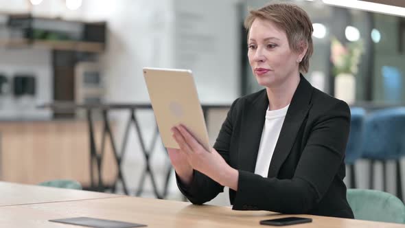 Serious Professional Businesswoman Using Tablet in Office