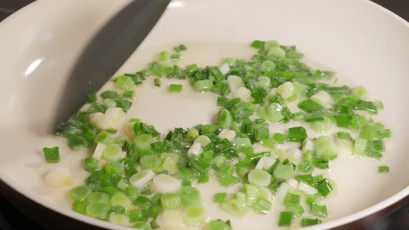 Hot oil frying green scallion onion in ceramic pan 4K 2160p UltraHD footage -Young onion in ceramic 
