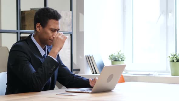 Pensive Black Man Thinking and Working on Laptop