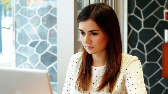 Attentive businesswoman using laptop