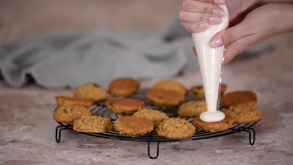 Confectioner Decorating Cookies with Cream