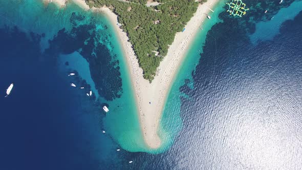 Aerial view of people sunbathing on a sandy beach on the island of Brac, Croatia