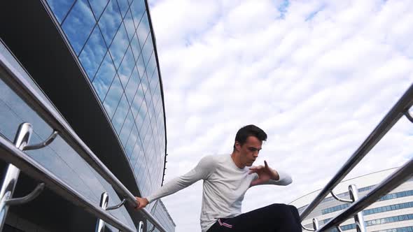 Young man is doing parkour in urban place.