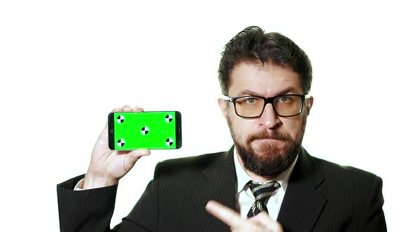 Concept Mockup. Bearded Businessman with Glasses Holding a Green Screen Smartphone.