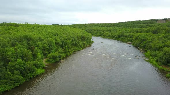 Aerial Shoot of Clean River in Green Forests and Hills in Wild Kola Peninsula Areas