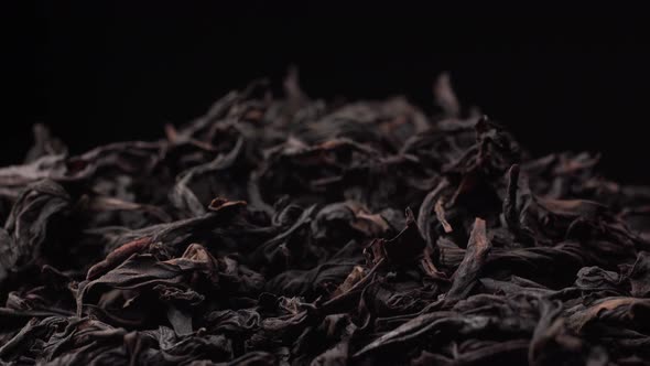 Magnificent Cinematic Footage of Black or Green Tea Rotating on Black Background. The Texture of the
