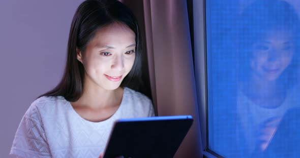 Young woman use of tablet computer at night