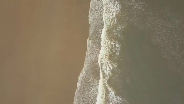 Aerial birds eye view drone footage of waves crashing onto the beach, Seaburn Beach, Sunderland.