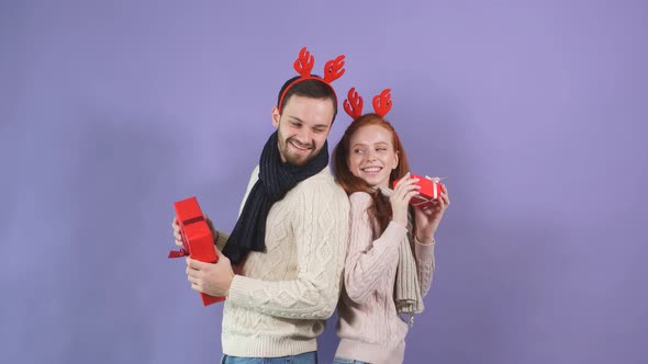 Cheerful Married Couple in White Sweaters Have Fun and Dance with Christmas Gifts in Rukahs