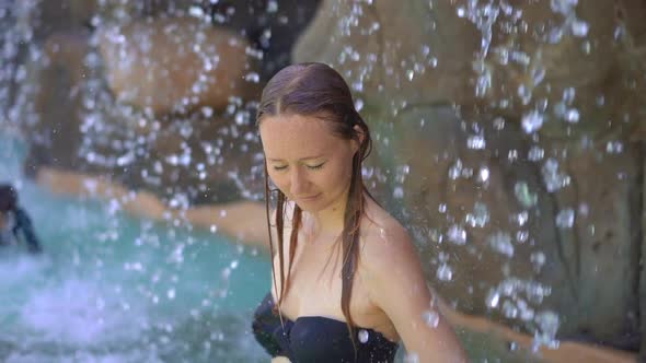 A Young Woman in a Tropical Resort with Hot Springs, Waterfalls and Swimming Pools with Hot Mineral