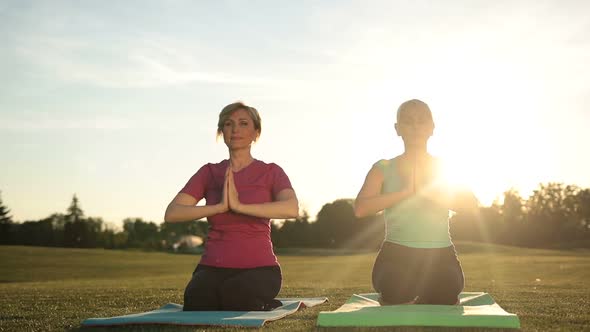 Women Yoga Meditating in Lotus Pose Hands Overhead