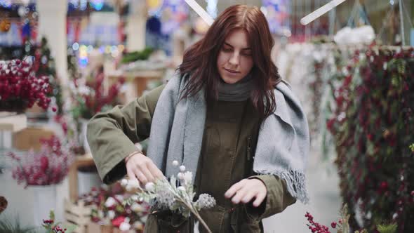 A Young Beautiful Woman Walks Around the Store and Selects Christmas Decorations and Decorations to