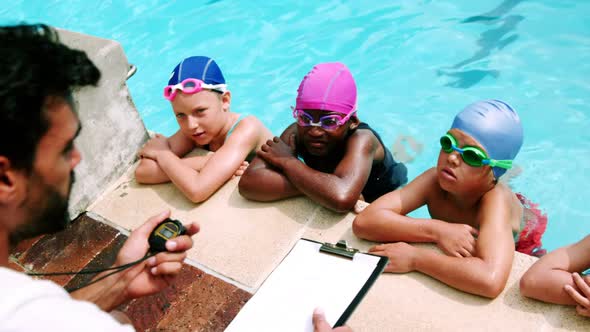 Coach giving swimming lesson to his students