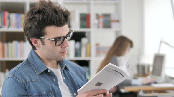 Creative Man Reading Book in Office
