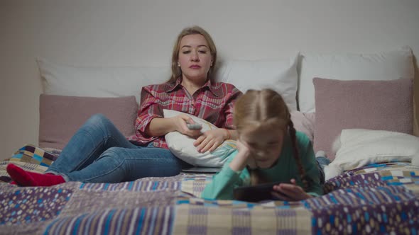 Family with Child Relaxing on Bed in the Evening