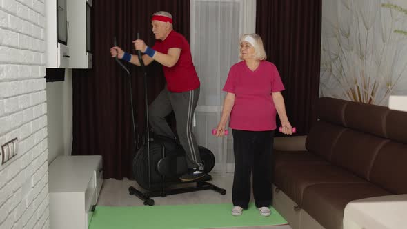 Senior Man Woman Doing Vitality Weight Lifting Sport Dumbbells Exercises and Using Orbitrek at Home