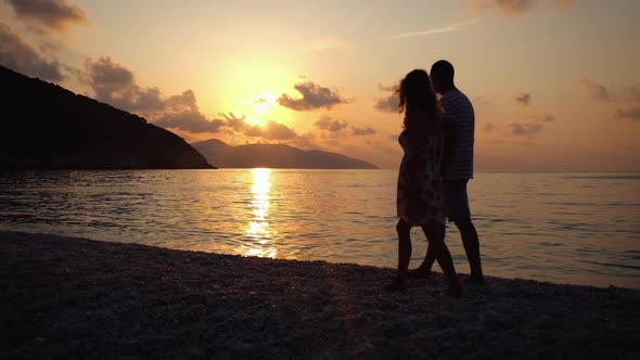 Happy family walking at beach at sunset over the sea. Slow molion footage