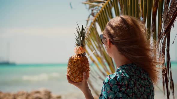 Blonde Travel Girl Relaxing On Caribbean Beach Saona Island. Girl Drinking Pina Colada On Beach.